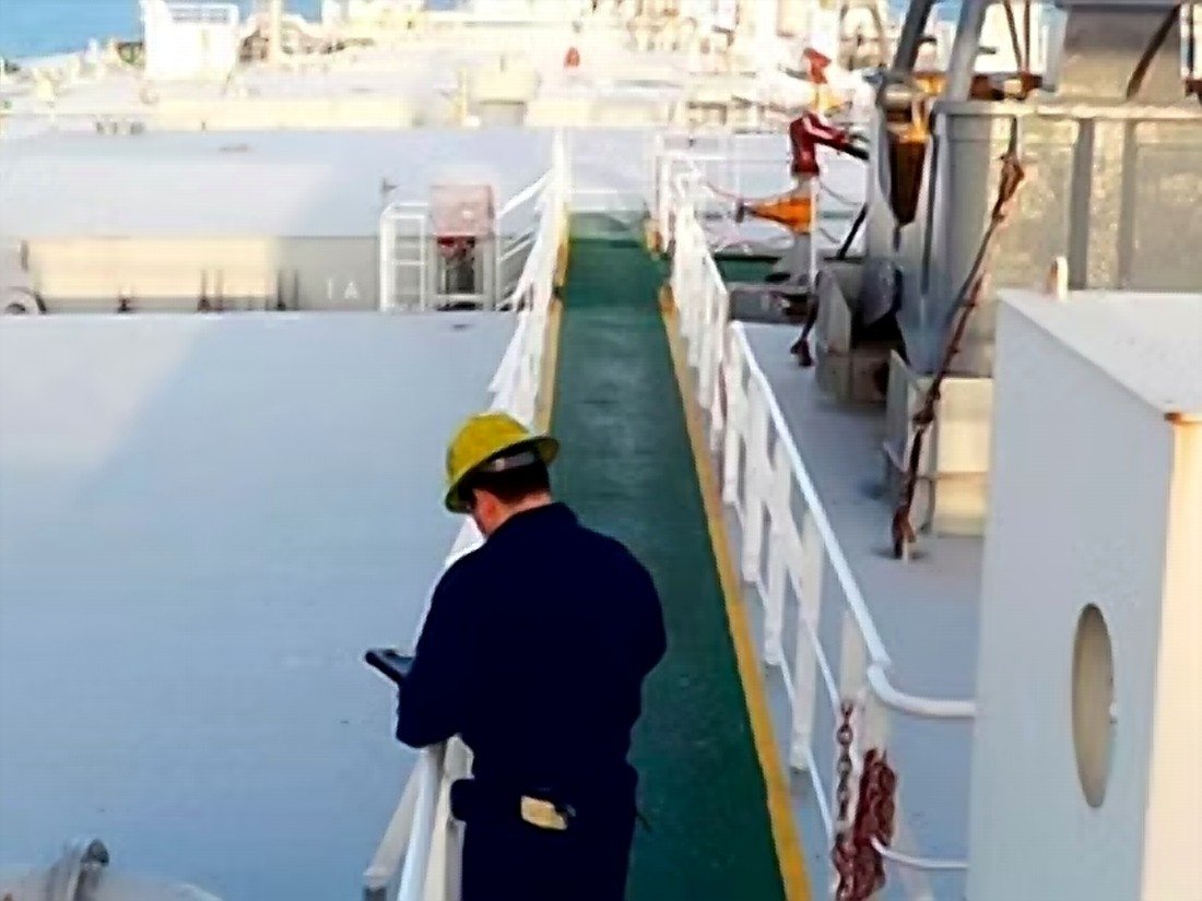 Crew member conducting a deck safety walk-through with a handheld device
